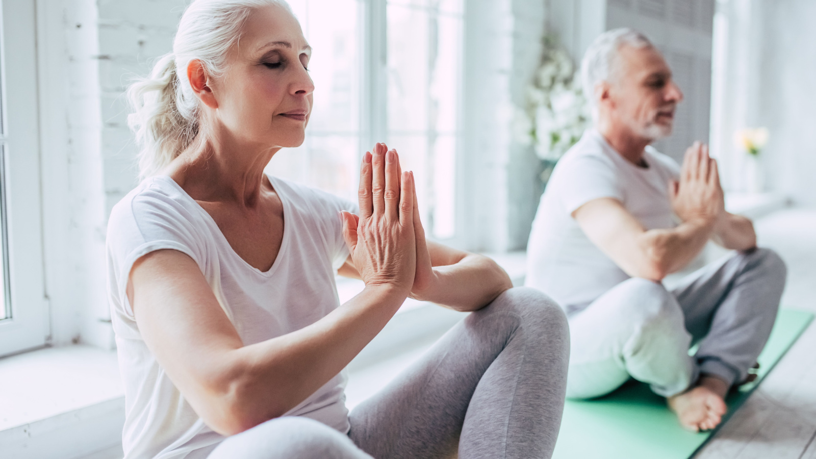 Couple Woman Mature Senior Yoga Meditation Relax Health Gym 4 PM production Shutterstock